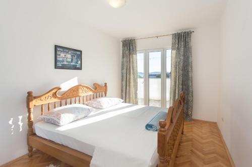ein Schlafzimmer mit einem großen Bett und einem Fenster in der Unterkunft Apartment Lucy by the sea with a private pool in Kaštela