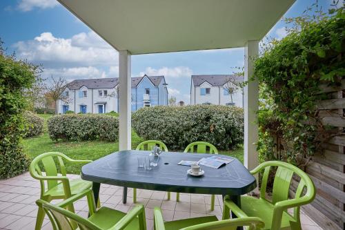 une table et des chaises bleues sur une terrasse dans l'établissement L'Alouette - Appt en résidence avec terrasse, à Courseulles-sur-Mer