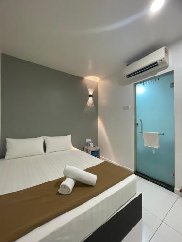 a bedroom with a bed with a towel on it at Hotel Lavender Inn in Melaka