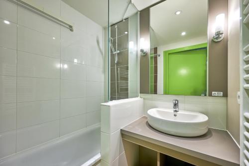 une salle de bain blanche avec un lavabo et un miroir dans l'établissement L'Alouette - Appt en résidence avec terrasse, à Courseulles-sur-Mer