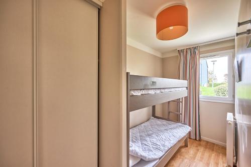 Ce lit superposé se trouve dans un dortoir doté d'une fenêtre. dans l'établissement L'Alouette - Appt en résidence avec terrasse, à Courseulles-sur-Mer