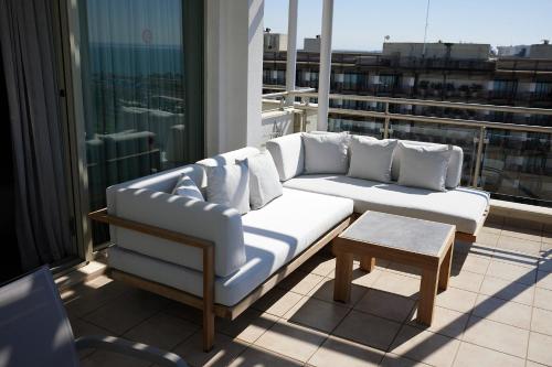 a white couch and a table on a balcony at Lara Barut Collection-Ultra All Inclusive in Lara