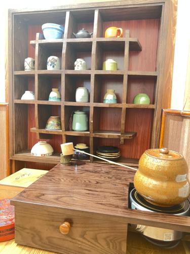 a display cabinet with bowls and plates in it at Samatha Hotel Bai Chay, Ha Long in Ha Long