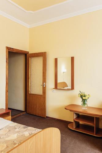 a room with a bed and a door and a table at Hotel Vesna in Truskavets