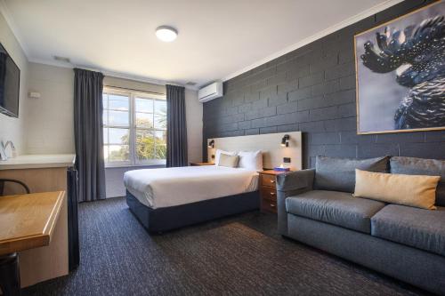 a hotel room with a bed and a couch at The Mulgrave Motel in Mulgrave