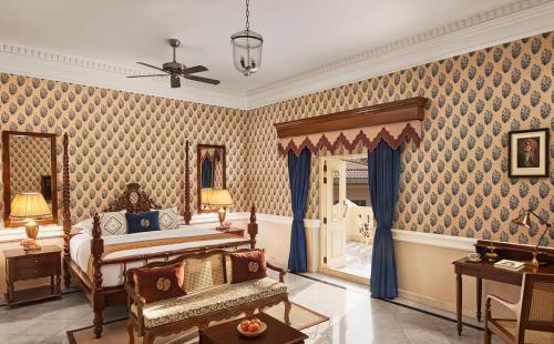 a bedroom with a king sized bed and blue wallpaper at Raajkutir - IHCL SeleQtions in Kolkata