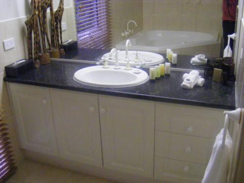 a bathroom with a sink and a bath tub at Weeroona Bed And Breakfast in Rye