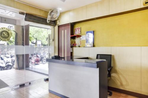 a restaurant lobby with a counter and a window at Collection O Hotel Udit Plaza in Bhopal