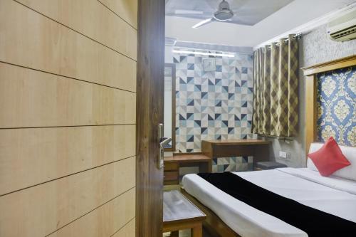 a bedroom with a bed with a red pillow on it at Collection O Hotel Udit Plaza in Bhopal