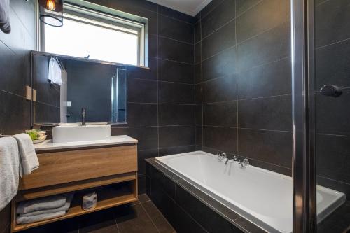 uma casa de banho com uma banheira e um lavatório em The Mulgrave Motel em Mulgrave