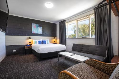 pokój hotelowy z łóżkiem i kanapą w obiekcie The Mulgrave Motel w mieście Mulgrave
