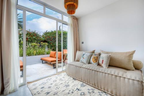 a living room with a couch and a sliding glass door at Signature Agadir Villa Luxe for 4 or 6 PX in Agadir