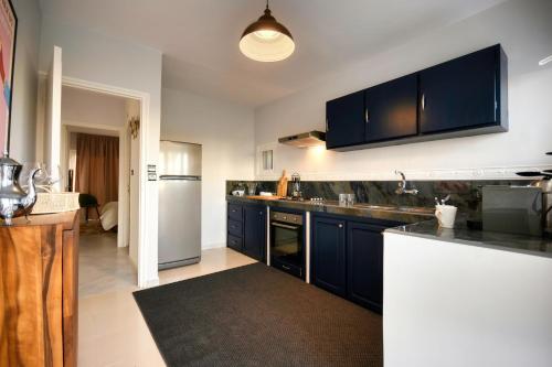 a kitchen with blue cabinets and a white refrigerator at Signature Agadir Villa Luxe for 4 or 6 PX in Agadir