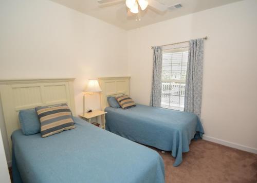a bedroom with two blue beds and a window at Iron Wood 1721 by Palmetto Vacation Rentals in Myrtle Beach