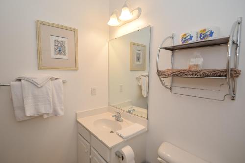 a white bathroom with a sink and a mirror at Iron Wood 1721 by Palmetto Vacation Rentals in Myrtle Beach