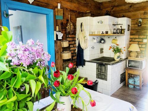 een keuken met een tafel met bloemen in een kamer bij Magiczne Podlasie 