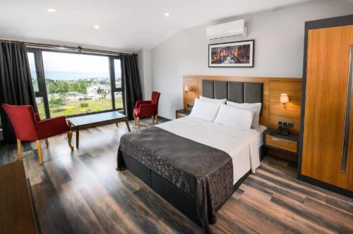 ein Hotelzimmer mit einem Bett und einem großen Fenster in der Unterkunft EMAY OTEL in Trabzon