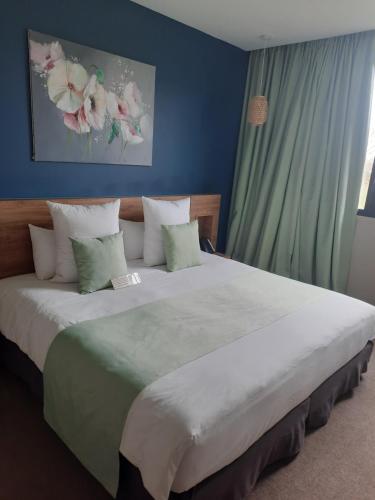 a bedroom with a large white bed with pillows at Hôtel & Restaurant La maison des blés in Boutervilliers