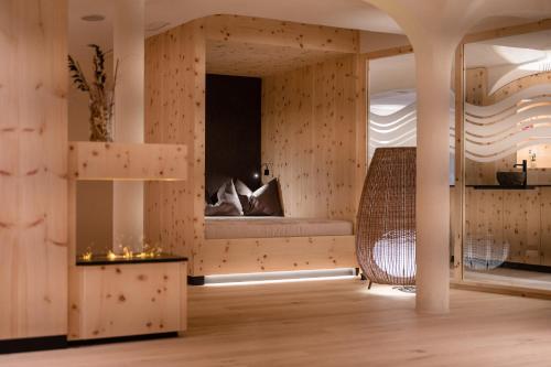 a room with a mirror and a rattan chair at Alpine Nature Hotel Stoll in Valle Di Casies