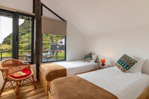 Habitación con 2 camas, silla y ventana en Cork House - Fernandes Cottage en Ponta Delgada