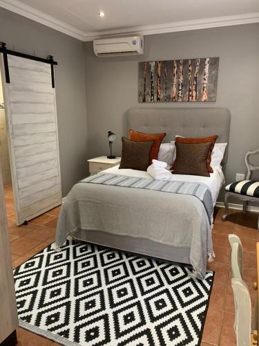 a bedroom with a large bed with a black and white rug at Seba Cottages Mokopane in Mokopane