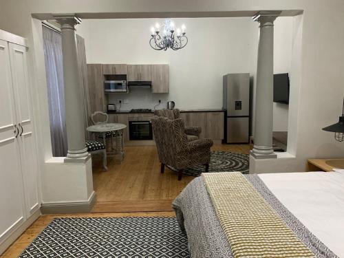 a bedroom with a bed and a living room with a kitchen at Seba Cottages Mokopane in Mokopane