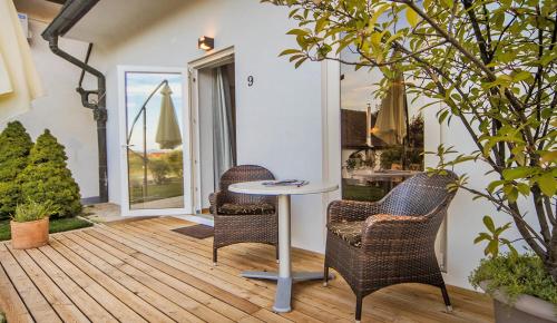 a patio with two chairs and a table on a deck at Hotel Pok Garni in Brezovica