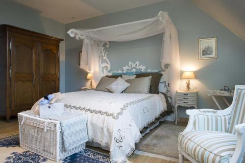 a bedroom with a white bed with a canopy at Lyolyl BnB in Sainte-Croix-sur-Orne