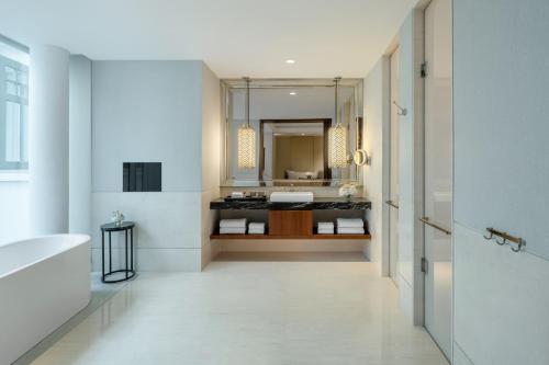 a bathroom with a sink and a tub and a mirror at The Capitol Kempinski Hotel Singapore in Singapore