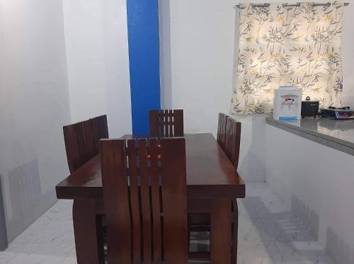 une table en bois avec deux chaises et un comptoir dans l'établissement Baguio La Famille Residences, à Baguio