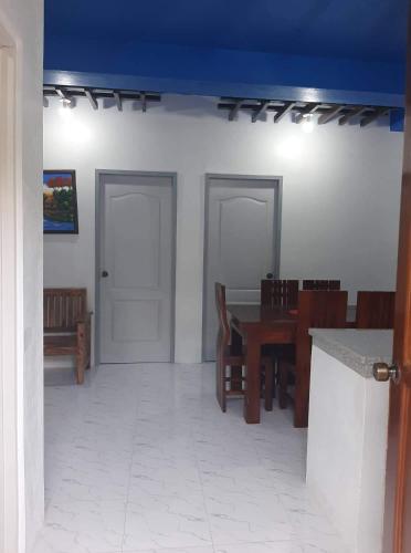 une salle à manger avec une table et des chaises et un plafond bleu dans l'établissement Baguio La Famille Residences, à Baguio