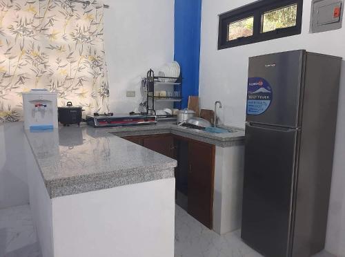 a kitchen with a refrigerator and a counter top at Baguio La Famille Residences in Baguio