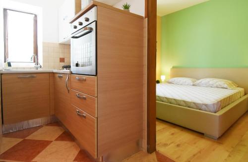 a small bedroom with a bed and a kitchen at Apartman Barkunada in Vodnjan