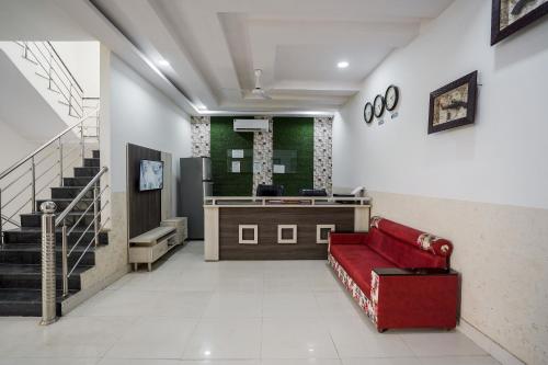 a lobby with a red couch and a counter at Hotel Prime Rose in Kurukshetra