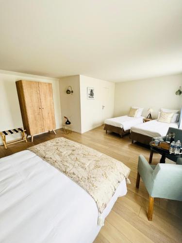 a large bedroom with two beds and a couch at Hôtel des Isles in Barneville-Carteret