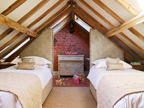 two beds in a attic bedroom with exposed beams at The Carthouse in Ledbury