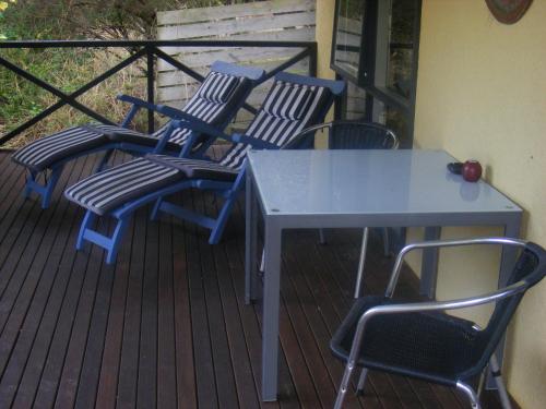 four chairs and a table on a deck at Weeroona Bed And Breakfast in Rye