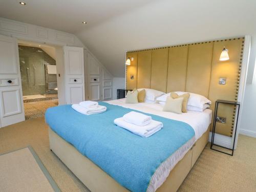 a bedroom with a large bed with towels on it at The Millhouse in Ledbury