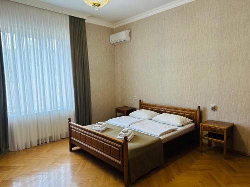 a bedroom with a bed and a large window at Guest House Kartuli Suli in Tʼelavi