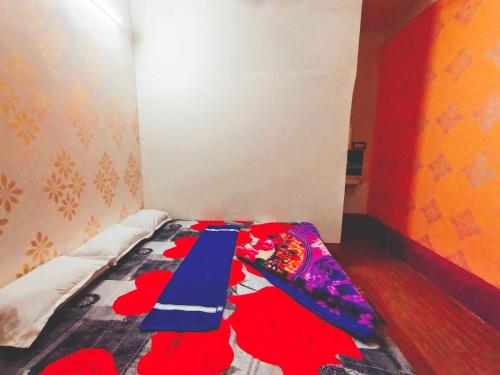 Habitación pequeña con cama con flores rojas. en SPOT ON Ganguly Hotel Lodging And Fooding, en Purulia