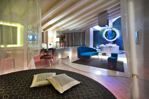a living room with a blue chair and a couch at Vip's Motel Luxury Accommodation & Spa in Lonato del Garda