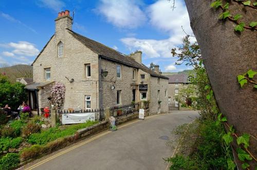 an old stone house with a street in front of it at Ramblers Rest in Castleton