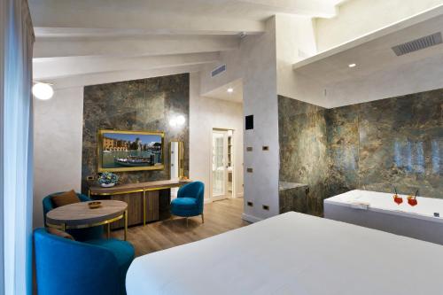 a hotel room with a bed and a table and chairs at Vip's Motel Luxury Accommodation & Spa in Lonato del Garda