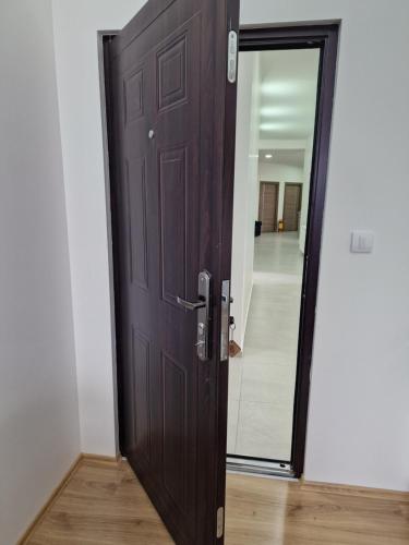 a wooden door in a hallway with a mirror at Vurk INN Paracin in Paraćin