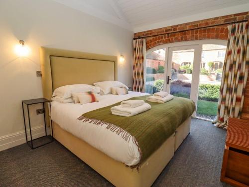 a bedroom with a large bed with towels on it at The Piggery in Ledbury