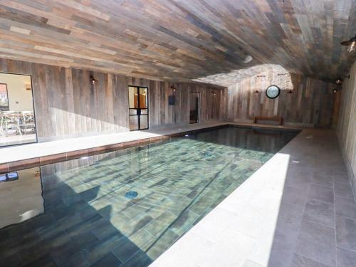 an indoor swimming pool with a wooden ceiling at The Piggery in Ledbury