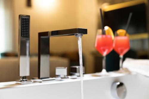 a water fountain with two glasses on a table at Vip's Motel Luxury Accommodation & Spa in Lonato del Garda