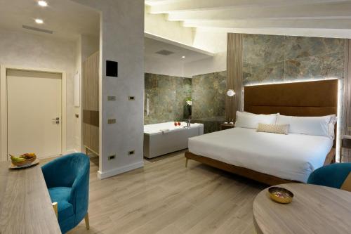a hotel room with a bed and a bath tub at Vip's Motel Luxury Accommodation & Spa in Lonato del Garda
