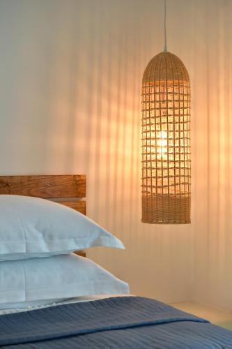 a bedroom with a bed and a chandelier at Ammos Luxury Rooms & Home in Naousa