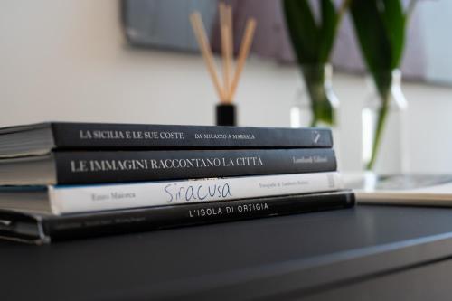 a stack of books sitting on top of a table at Ortigia's gate in Syracuse